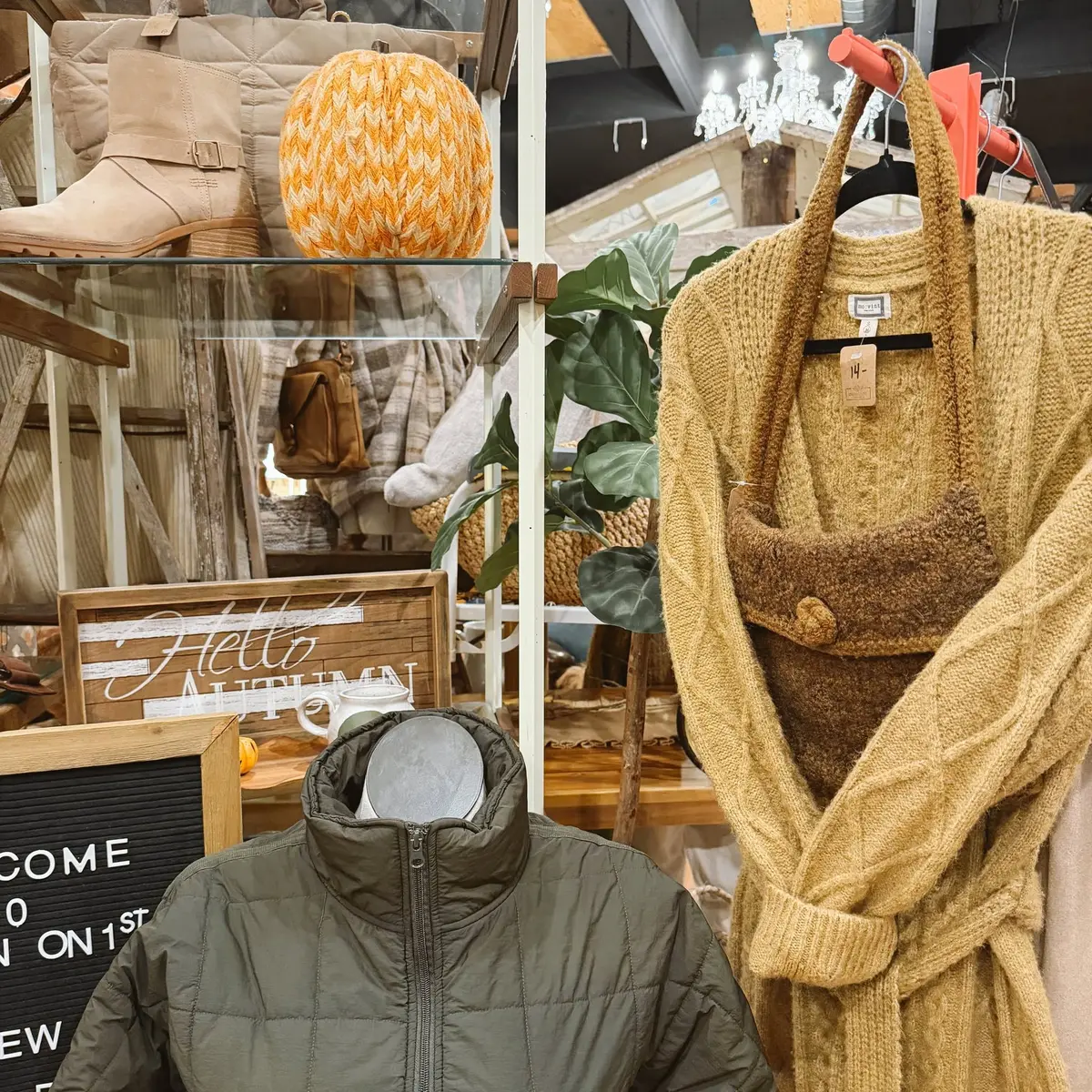 Camel cable-knit wrap cardigan and olive puffer on the shop floor